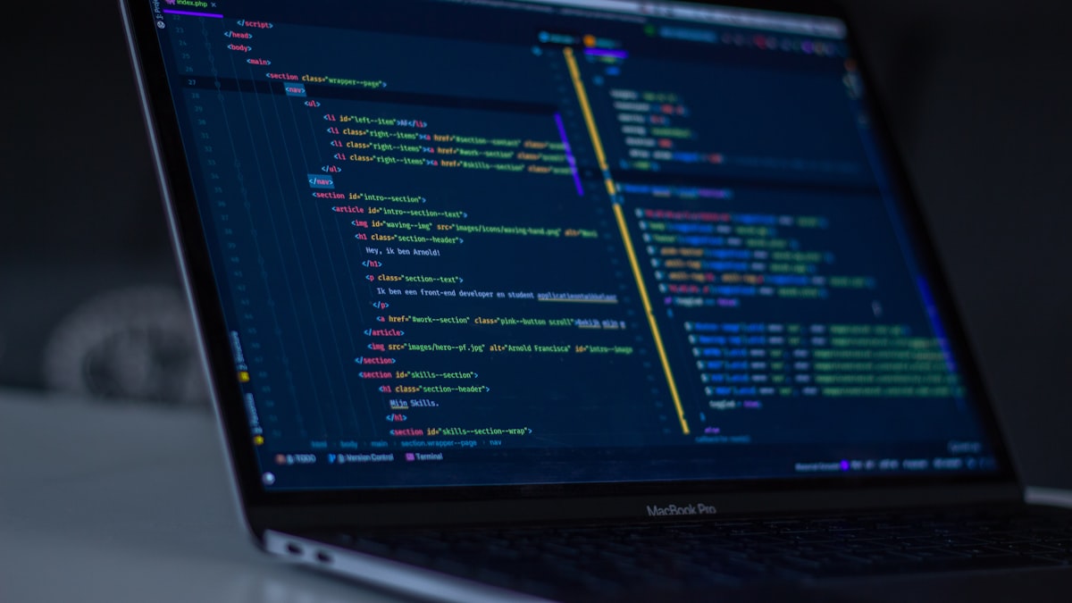 A software developer working at a desk with code on screen