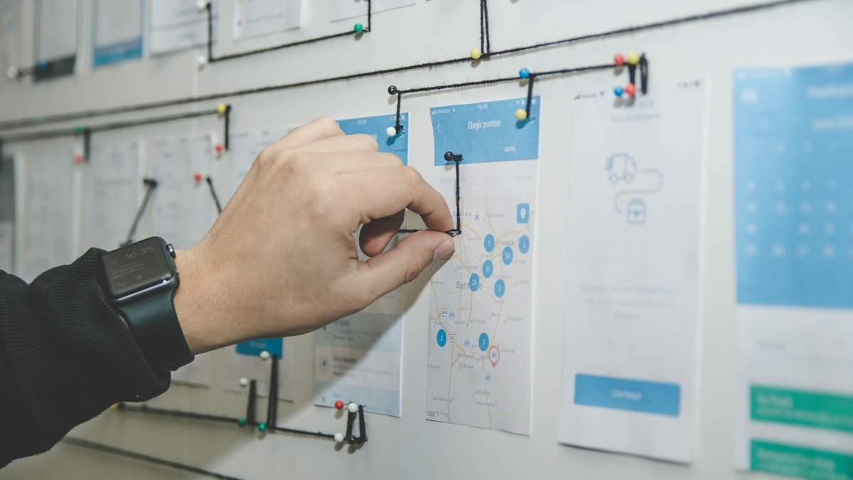 People working through numbers on a whiteboard in a meeting room